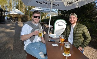 Die Fußballer Jonas Böhme (l.) und Bastian Just genießen nach der Radtour ein kühles Getränk unter Bäumen im Biergarten. - Karin Prignitz