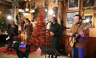 Güterslohs Bürgermeister Norbert Morkes (von links) und seine Harsewinkeler Kollegin Sabine Amsbeck-Dopheide singen mit dem Duo "White Coffee" Weihnachtslieder. An Heiligabend ab 16 Uhr ist der Auftritt im Video zu sehen. - Screenshot/Facebook "GTönt"