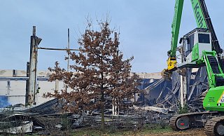 Bagger sind damit beschäftigt, Metallteile und Seitenverkleidungen zu entfernen, um an letzte Glutnester zu gelangen. - Birgit Vredenburg