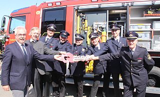 Bürgermeister Norbert Hofnagel (v. l.) und Pfarrer Bernd Götze freuen sich mit der Feuerwehr über das neue Fahrzeug. - Burkhard Battran