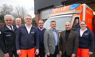 Vor der Rettungswache: (v. l.) Martin Münsterteicher, Rüdiger Kache, Alfons Twielemeier, Erik Ernst, UlrichKnorr, Andreas Bee, Lena Haß und im Rettungswagen Gerrit Fiebig. - Klaus Karenfeld