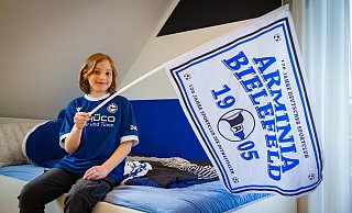 Die Wand in seinem Zimmer hat Einlaufkind Henri Padur in Aminiafarben gestrichen, die Jubiläumsfahne kürzlich im Stadion ergattert. - Mike-Dennis Müller