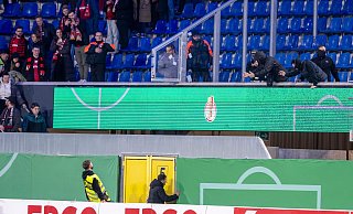 Einige wenige Fans des SC Paderborn (r.) liefern sich an der Grenze zu den Gästeblöcken heftige Wortgefechte mit Leverkusener Anhängern, die im Innenraum von Ordnern zurückgehalten werden. Letzteres ist auf diesem Bild allerdings nicht zu sehen. - dpa