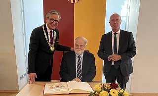 Im Beisein von Bürgermeister Michael Dreier (l.) und Rudolf Wansleben (r.) trägt sich Festredner Manfred Lütz ins Goldene Buch der Stadt Paderborn ein. - Susanne Göbel