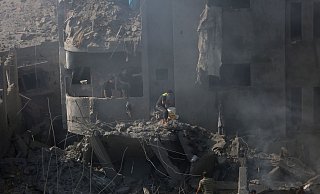 Palästinenser suchen in den Trümmern eines zerstörten Gebäudes in Bureij nach Überlebenden. - Mohammed Dahman/AP/dpa