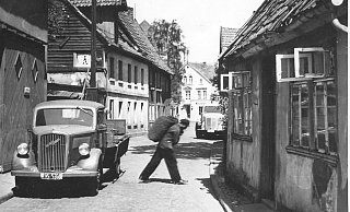 Lieferservice: Es ist Sommer in den Sechzigern und der Mann hat schwer zu schleppen. Nicht ganz klar ist, ob er Eierkohlen, Briketts oder eventuell doch Kartoffeln direkt in den Keller transportiert. - Foto: Georg Heese (Kommunalarchiv)
