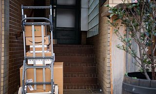 Gestapelte Pakete in einem Hauseingang. Das Postgesetz ist in seinen wesentlichen Teilen schon seit 1998 gültig. - Sebastian Gollnow/dpa