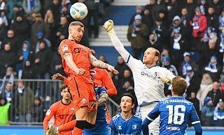 Felix Platte (l.) kommt vor Dominik Reimann zum Kopfball. Sekundenbruchteile landet die Faust des Magdeburger Torhüters am Kopf des SCP-Stürmers. - picture alliance/dpa
