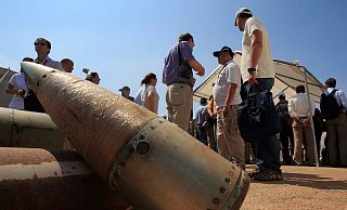 Aktivisten und Mitglieder internationaler Delegationen stehen neben Streubombeneinheiten während eines Besuchs auf einem libanesischen Militärstützpunkt. - Mohammad Zaatari/ap/dpa