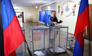 Eine Frau gibt in einem Wahllokal in Donezk ihre Stimme ab. - AP/dpa