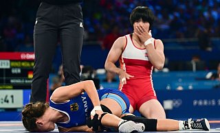 Krümmte sich vor Schmerz: Ringerin Annika Wendle (l.) in ihrem Bronze-Kampf. - Sina Schuldt/dpa