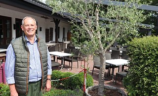 Klaus Margenberg steht am Rand der Terrasse des Becker Krugs. Dort ist viel Platz für Abstand zwischen den Tischen. - Dirk Windmöller