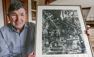 Bomben auf Rehme: Horst Jäcker zeigt eine alte Luftaufnahme eines Aufklärers der Royal Air Force vom 22. März 1945. Auf dem Foto sichtbar sind die zahlreichen Bombenkrater. Horst Jäcker hat bestimmte Bereiche von Rehme mit Zahlen gekennzeichnet und unter dem Bild erklärt - weil die Aufnahme jahrelang in seinem Autohaus hing. - Foto: Nicole Sielermann