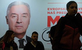 Der Wahlkampf ist zu Ende: Menschen gehen an einem Plakat des pro-westlichen Amtsinhabers Milo Djukanovic vorbei. - Risto Bozovic/AP/dpa