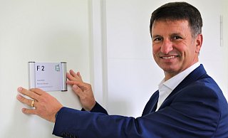 Michael Stickeln mit dem Namensschild am Eingang zu seinem neuen Büro „F 2“ im Höxteraner Kreishaus. - Simone Flörke