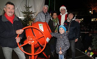 Reinhard Schumacher, Rolf-Bernd Eggersmann, Britta Hohn, Heinz Buschmann und Kerstin Kottenbrink sowie Mika waren das Verlosungsteam auf der Bühne des Espelkamper Weihnachtsmarkts. - Klaus Frensing