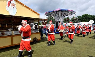 Eine holländische Musikkapelle in Weihnachtsmann-Kostümen spielt auf dem Weihnachtsmarkt in Solingen. - Foto: Roberto Pfeil/dpa