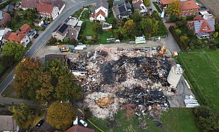 Luftaufnahme der Brandstelle in Hille-Holzhausen: Die Überreste der Holz- und Kunststoffbaufirma zeigen das Ausmaß der Zerstörung nach dem Großbrand. - Alex Lehn