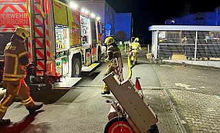 Feuerwehrleute eilen zur Einsatzstelle an der Uhlandstraße, wo ein Balkon in Flammen steht. - Ralph Meyer