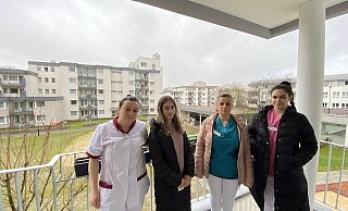 Dolmetscherin Sultone Rexhepaj (v. l.), Enisa Mahmuti, Vjolica Kurti und Klaudia Haxhiu auf dem Balkon des Neubaus am Seniorenzentrum Bethel, dessen andere Gebäudeteile im Hintergrund zu sehen sind. - Nicole Sielermann
