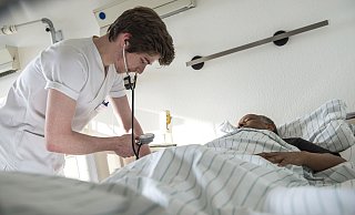 Krankenpflegeschüler misst den Blutdruck eines Patienten. - Heike Lyding