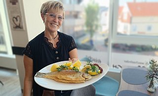 Freitags ist Fischtag im BüCafé: Andrea Finkemeyer mit einer ganzen Forelle, die es im Mittagsangebot für 12,90 Euro gibt. - Sven Hauhart