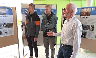 Mit seinen Leistungskurs-Schülern Maximilian Müller (v. l.), Felix Niehaus und Louis Schimmud (verdeckt) und anderen, erstellte OPG-Lehrer Klaus Droste die Ausstellung zum Mauerfall vor 30 Jahren. - Ulrich Finkemeyer