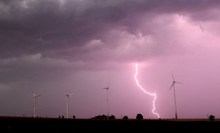 Eine Unwetterfront mit Blitzen, Starkregen und Sturmböen zieht über Windräder hinweg. - picture alliance / Julian Stratenschulte/dpa