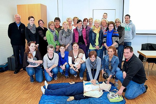 Viel gelernt: Mit Hilfe einer Reanimationspuppe üben die Frauen die Herzmassage. Bernhard Meier (l.), Kevin Schenkel (5.v.r.), Michael Meier (r.) und Sven Glasneck (vorne r.) sind mit ihren Schülerinnen sehr zufrieden. In der Mitte eine Säuglingspuppe, das Baby links ist echt. - © FOTO: VOSS