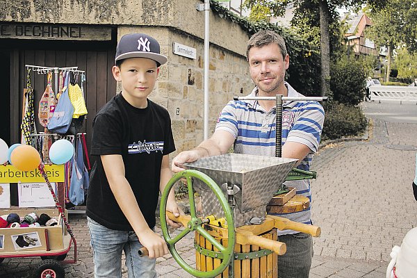 An der Apfelpresse: Marlon Biederbick macht aus heimischen Äpfeln frische gepressten Apfelsaft. David Koisirk passt auf. - © Patricia Speith