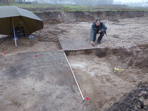Grabungsleiter Sven Knippschild untersucht ein 2.000 Jahre altes Grubenhaus bei nasskaltem Novemberwetter. - © LWL-AfW/S. Spiong
