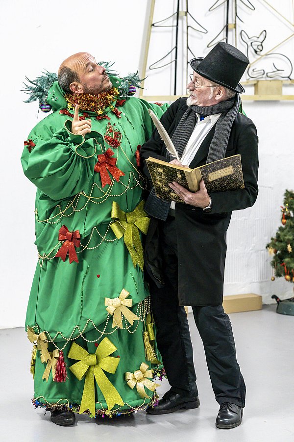 Auch wenn der Geist der gegenwärtigen Weihnacht (Frank Spiegel, links) nach Ansicht von Ebenezer Scrooge (Thomas Rüther) eine ausgesprochen bunte Erscheinung ist, ist seine Botschaft eindeutig: Der Geizhals muss sein Leben ändern. - © Abtei-Musical-Company