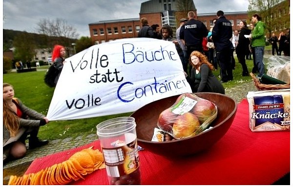 Oberstufenkollegiaten demonstrieren vor dem Polizeipräsidium. Sie wehren sich dagegen, dass die Entnahme von Lebensmitteln aus Müll kriminalisiert wird. Im Vordergrund steht ein Buffet, das komplett aus einem Abfallcontainer stammt. - © FOTO: SARAH JONEK