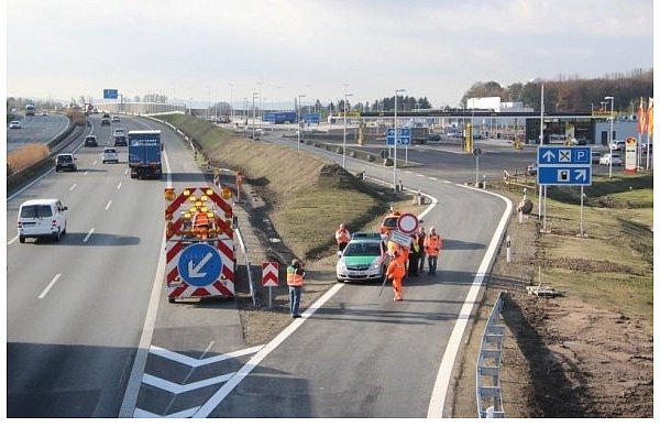 Ein Mitarbeiter trägt das Verbotsschild zu seinem Anhänger. Wenig später rollen die ersten Autos und Lkw auf die Rastanlage. Während die Tankstelle bereits fertig ist, eröffnet der eigentliche Rasthof im Hintergrund erst in einigen Wochen. - © FOTO: STEFAN BACKE