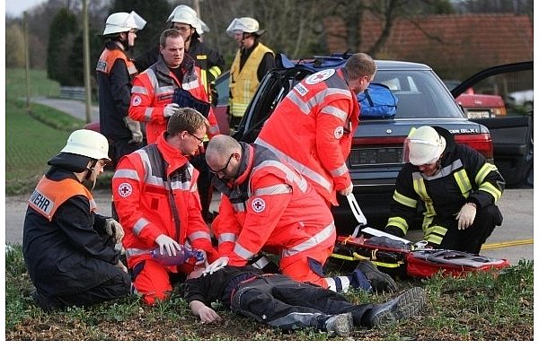 Während die Mitglieder der Freiwilligen Feuerwehr versuchen, eine Frau aus dem blauen Auto zu befreien, führen die Rettungssanitäter Wiederbelebungs-Maßnahmen an Thorben Frömel durch. Auch wenn alles nur gespielt ist wirkt der Probeeinsatz täuschend echt. - © FOTOS: NICO BUCHHOLZ
