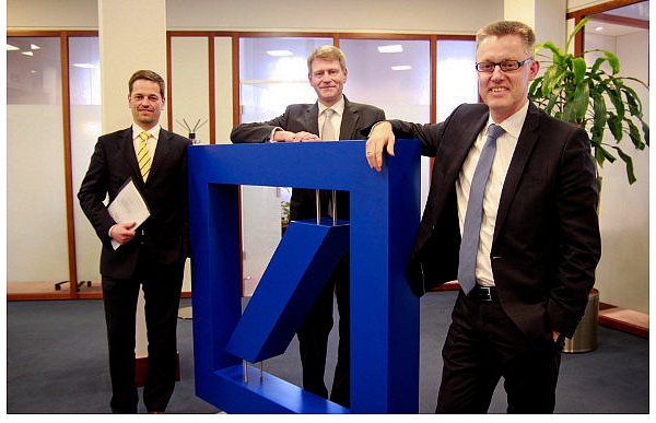 Marc Brinkhoff, Michael Lübbers und Markus Herpers (v. l.) Geschäftsleiter der Deutschen Bank in Gütersloh sind mit dem vergangenen Jahr zufrieden. Das Logo – in Gütersloh überdimensional im Schalterraum – wurde 1972 entwickelt. Der Schrägstrich soll kontinuierliches Wachstum symbolisieren, das Quadrat steht für Sicherheit. 100 Jahre früher verwendete die Bank noch den Kaiseradler. - © FOTO: M. SCHARLIBBE