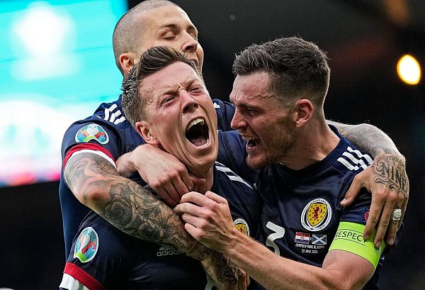 Schottlands Callum McGregor (M) und Andrew Robertson (r) jubeln über das 1:1. - © Petr David Josek/AP Pool/dpa