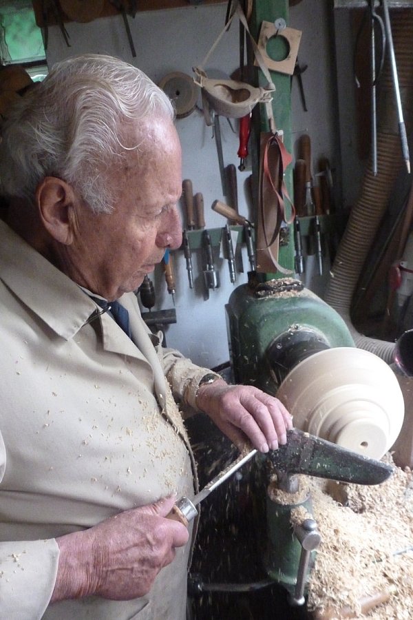 Herbert Neuhoff verschafft Holz an der Werkbank mit scharfen Instrumenten Rundungen. - © Wilhelm Ide