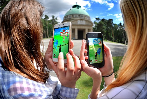 Realer Schauplatz: Diese beiden Pokémon-Spielerinnen versuchen, die virtuelle Arena am Krematorium auf dem Sennefriedhof einzunehmen. Dafür haben sie zuvor Pokémons mit bestimmten Fähigkeiten gefangen, die nun gegeneinander antreten können. - © Andreas Frücht