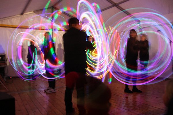 Auf der Bühne begeistert die Schulpoigruppe "School of Fire" der Erich-Kästner-Gesamtschule Bünde die Besucher mit einem bunten Lichtspektakel. - © Anthea Moschner
