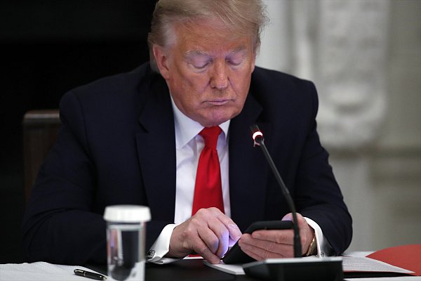 Präsident Donald Trump am Smartphone. US-Techmilliarde haben ein Interesse daran, dass auch in Europa in den sozialen Medien möglichst wenige Regeln gelten. - © picture alliance/dpa/AP