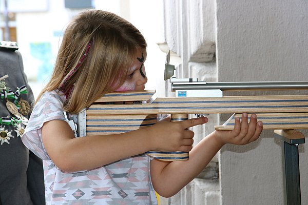 Am Schießstand: Marie (6) konzentriert sich, um das Lichtpunktgewehr ganz ruhig in der Hand zu halten. - © Nora Pfützenreuter