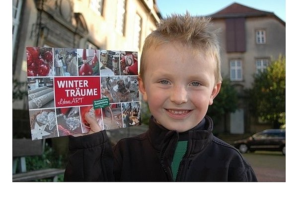 Mats, Sohn der Veranstalterin Katharina Kinkeldey, zeigt den Ankündigungsflyer der Willebadessener "Winterträume". - © FOTO: PRIVAT