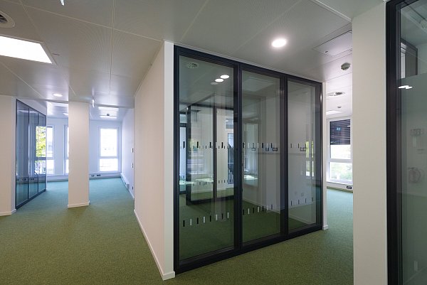 Ein Blick in das Gebäude R4: In den Büros sorgt der Einsatz von Glas für Transparenz. Hier abgetrennt ein Fokusraum, der etwa für persönliche Besprechungen genutzt werden kann. - © Universität Bielefeld / Mike-Dennis Müller