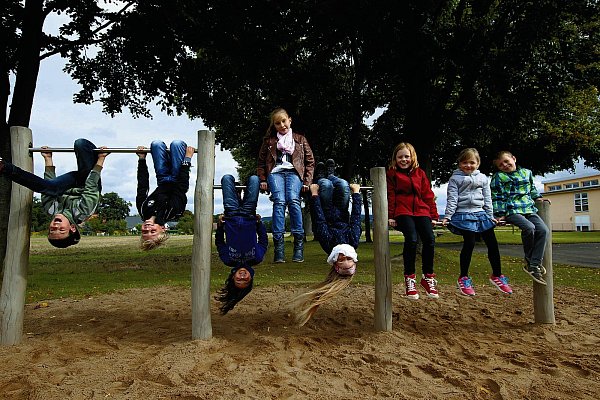 Haben Spaß: Lennard (v. l.), Nick, Alisa, Anabela, Pia, Mia, Lea und Erik baumeln an den Kletterstangen, die der Förderverein vor wenigen Jahren aufstellen ließ. - © Kristine Greßhöner
