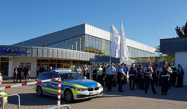 Düsseldorf: Polizisten stehen am späten Nachmittag vor dem Rheinbad, wo es zu einem Streit mit mehreren Hundert beteiligten Badegästen gekommen ist. Die Polizei rückte am Samstag mit Dutzenden Beamten an und versuchte zu schlichten. Der Betreiber des Bades entschloss sich am Abend zu einer vorzeitigen Schließung. - © picture alliance/dpa