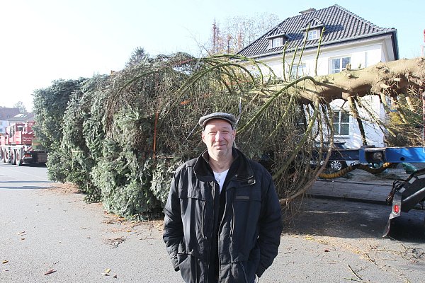 Froh: Der Bielefelder Lutz Konokpa hat in seinem Haus jetzt mehr Licht, weil die Tanne für den Herforder Weihnachtsmarkt gefällt worden ist. - © Peter Steinert