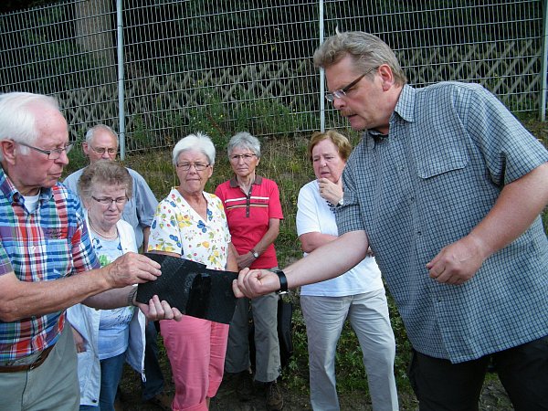 Hatte viele Informationen über die Deponie direkt vor der Haustür: Die Kunststoffdichtung ist eine der zahlreichen vorgeschriebenen Schichten der Deponieabdichtung. Andreas Dittmann (r.) zeigt den Wanderern ein Stück davon. - © Myriam Domke-Feiner