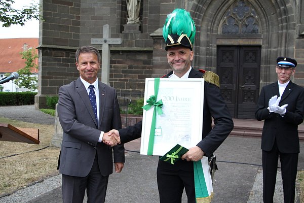 Großer Festumzug zu 200 Jahren Heimatschutzverein Lütgeneder: Urkunde und Glückwunsch: Landrat Michael Stickeln überreicht Oberst Elmar Nolte eine Urkunde und ein "kleines Geschenk" zum Jubiläum des Heimatschutzvereins. - © Saskia Jochheim