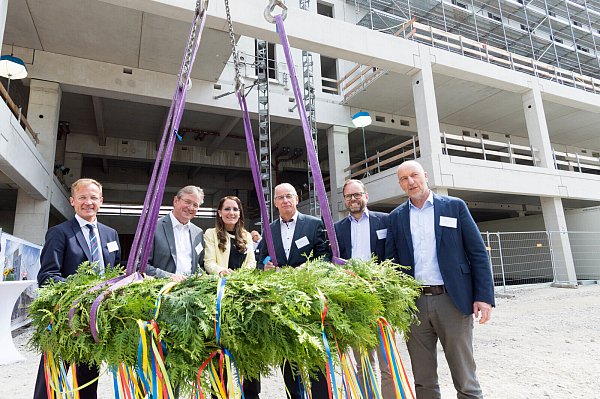 Staatssekretär Daniel Sieveke (v. l.), Bürgermeister Michael Dreier, Bahnhofsmanagerin Claudia Heck, Heinz Hillebrand (PB1), Carsten Kirchhoff (BEG) und Ludger Kloidt (NRW.urban) feiern das Richtfest des Paderborner Hauptbahnhofes. Im Hintergrund ist der fertige Rohbau zu sehen. - © Lena Henning